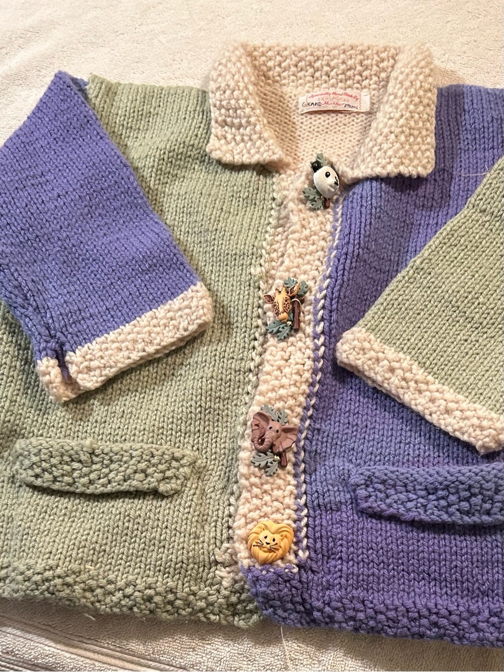 Kids hand knit cardigan block colors and animal buttons.